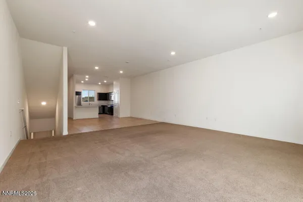 a view of empty room with a kitchen