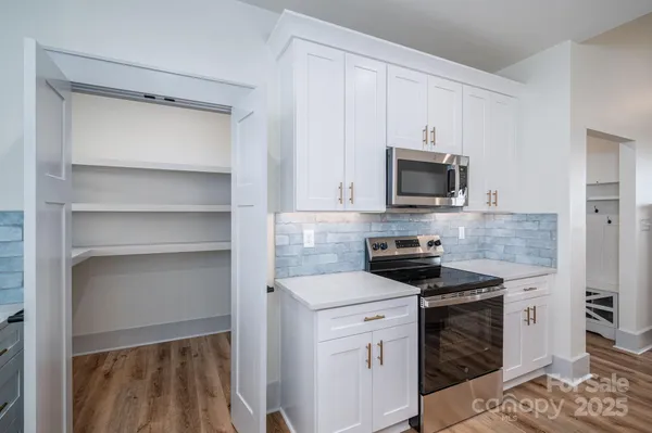 a kitchen with white cabinets and appliances