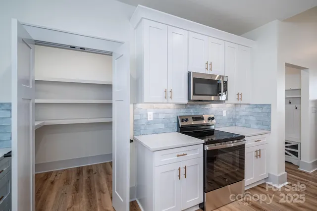 a kitchen with white cabinets and appliances