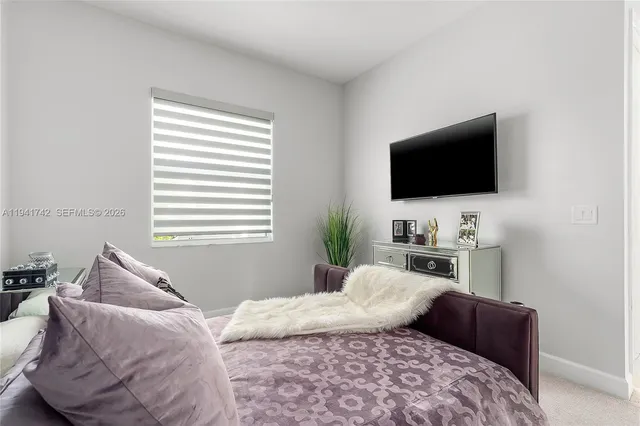 an aerial view of a tennis ground and a cars park side of the road