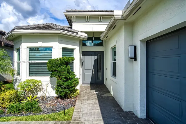a front view of multi story residential apartment building with yard and green space