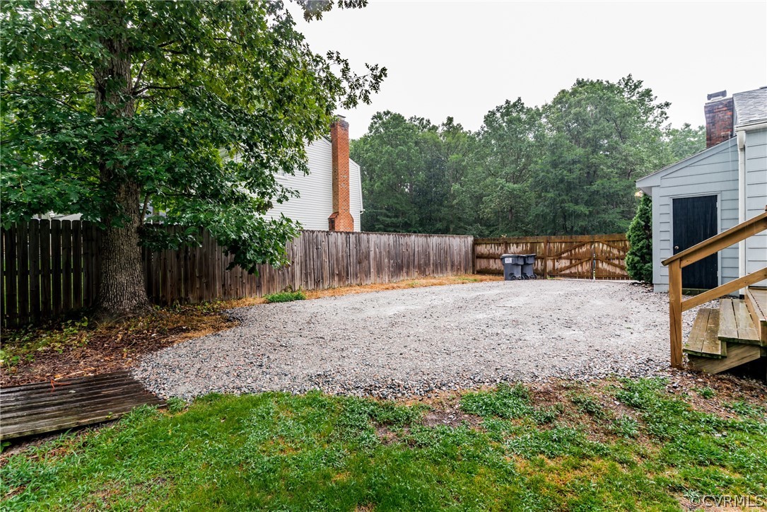 5242 Rollingway Road Chesterfield, VA 23832 - Photo 23 of 24 a view of a backyard with large trees and wooden fence