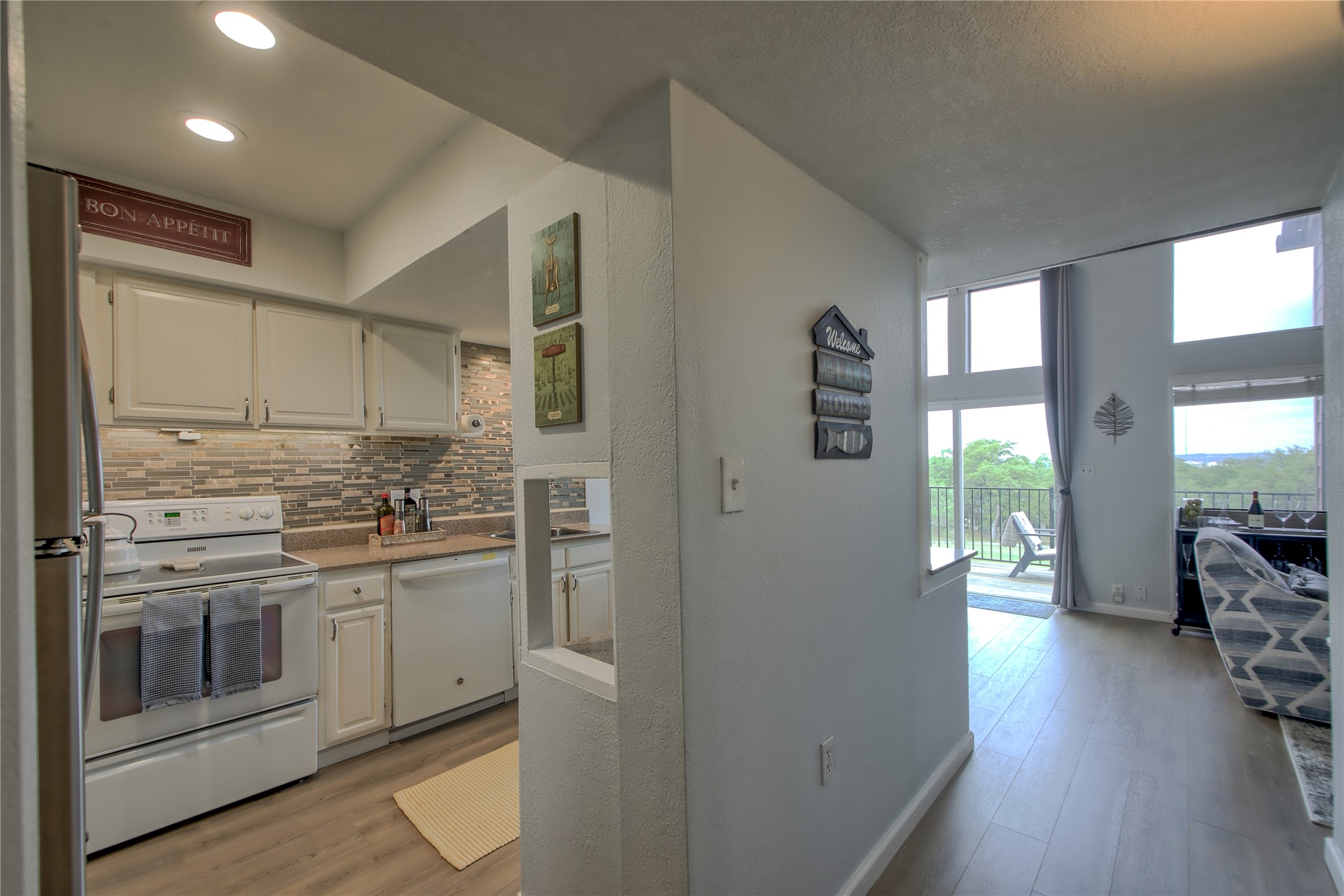 549 Demarett Drive Point Venture, TX 78645 - Photo 5 of 31 a kitchen with stainless steel appliances granite countertop a refrigerator a stove and a wooden floors