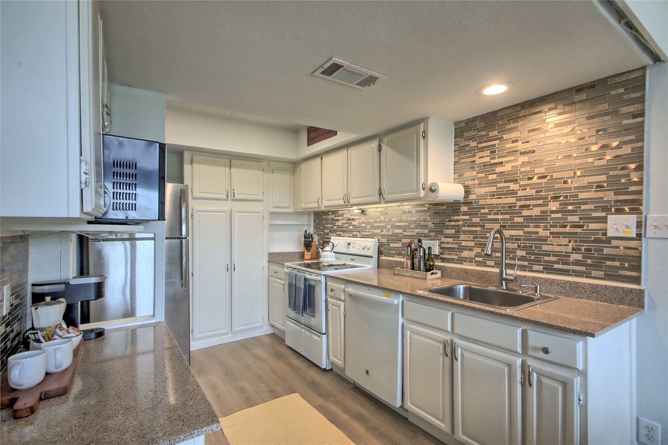 549 Demarett Drive Point Venture, TX 78645 - Photo 6 of 31 a kitchen with stainless steel appliances granite countertop a sink stove and refrigerator