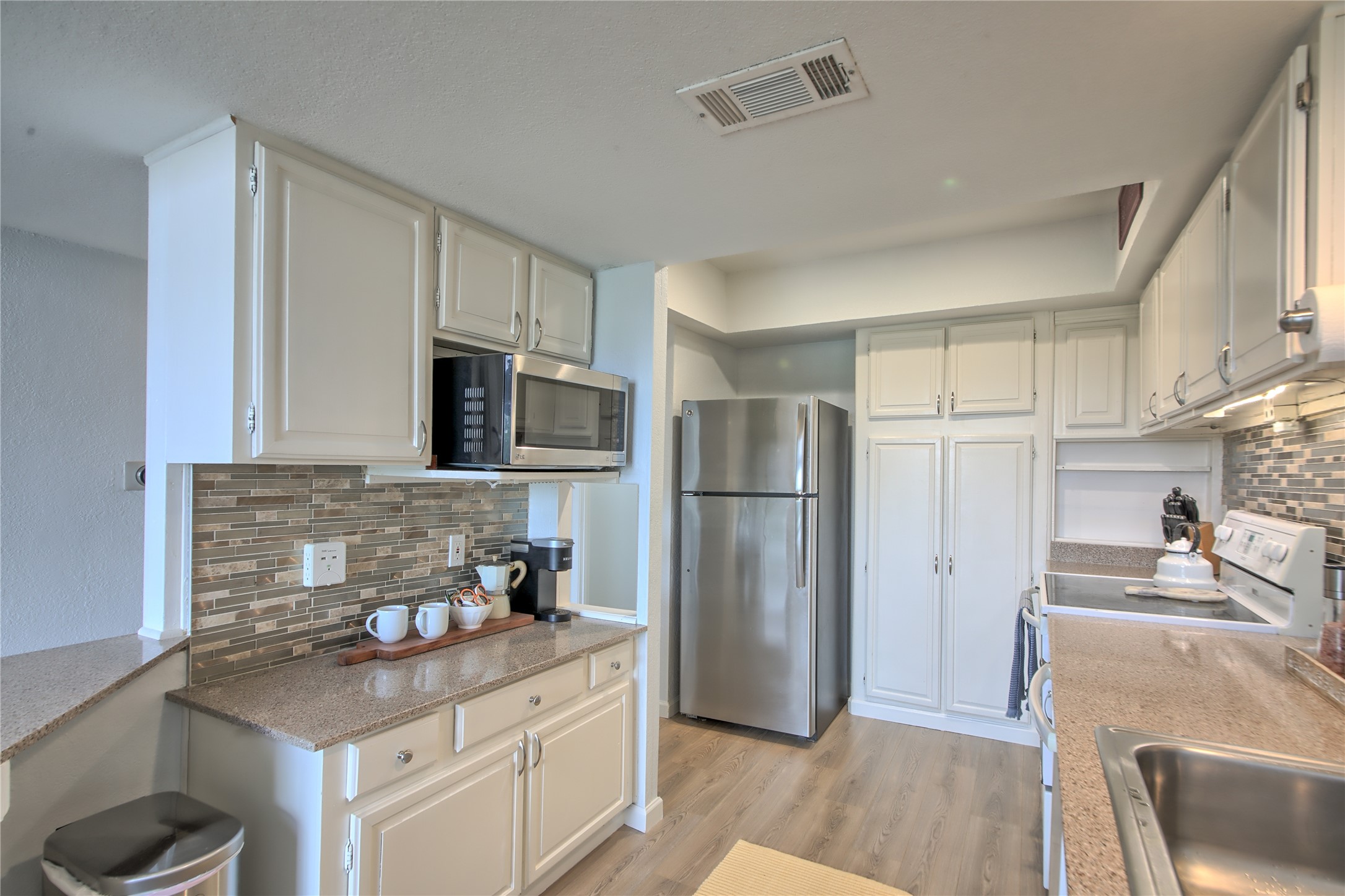 549 Demarett Drive Point Venture, TX 78645 - Photo 7 of 31 a kitchen with stainless steel appliances granite countertop a refrigerator and a sink