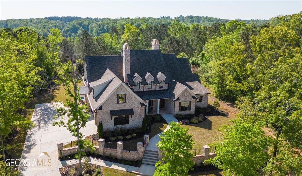 an aerial view of a house with a yard large trees