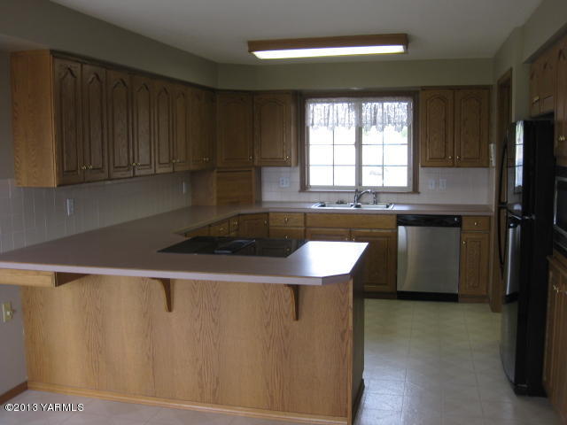 9530 Mieras Road Yakima, WA 98901 - Photo 13 of 55 a kitchen with granite countertop a sink a stove and refrigerator