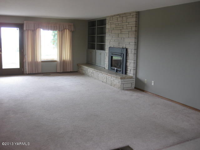 9530 Mieras Road Yakima, WA 98901 - Photo 10 of 55 an empty room with a fireplace and window