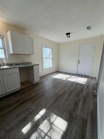 a view of a kitchen with granite countertop cabinets and wooden floor