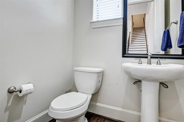 a bathroom with a toilet a sink and mirror