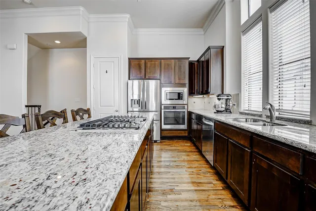 a large kitchen with kitchen island a sink stainless steel appliances and cabinets