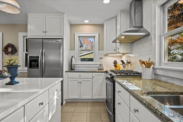 a kitchen with stainless steel appliances granite countertop a sink a stove and a refrigerator