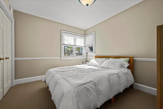 a large bed sitting in a bedroom next to a window