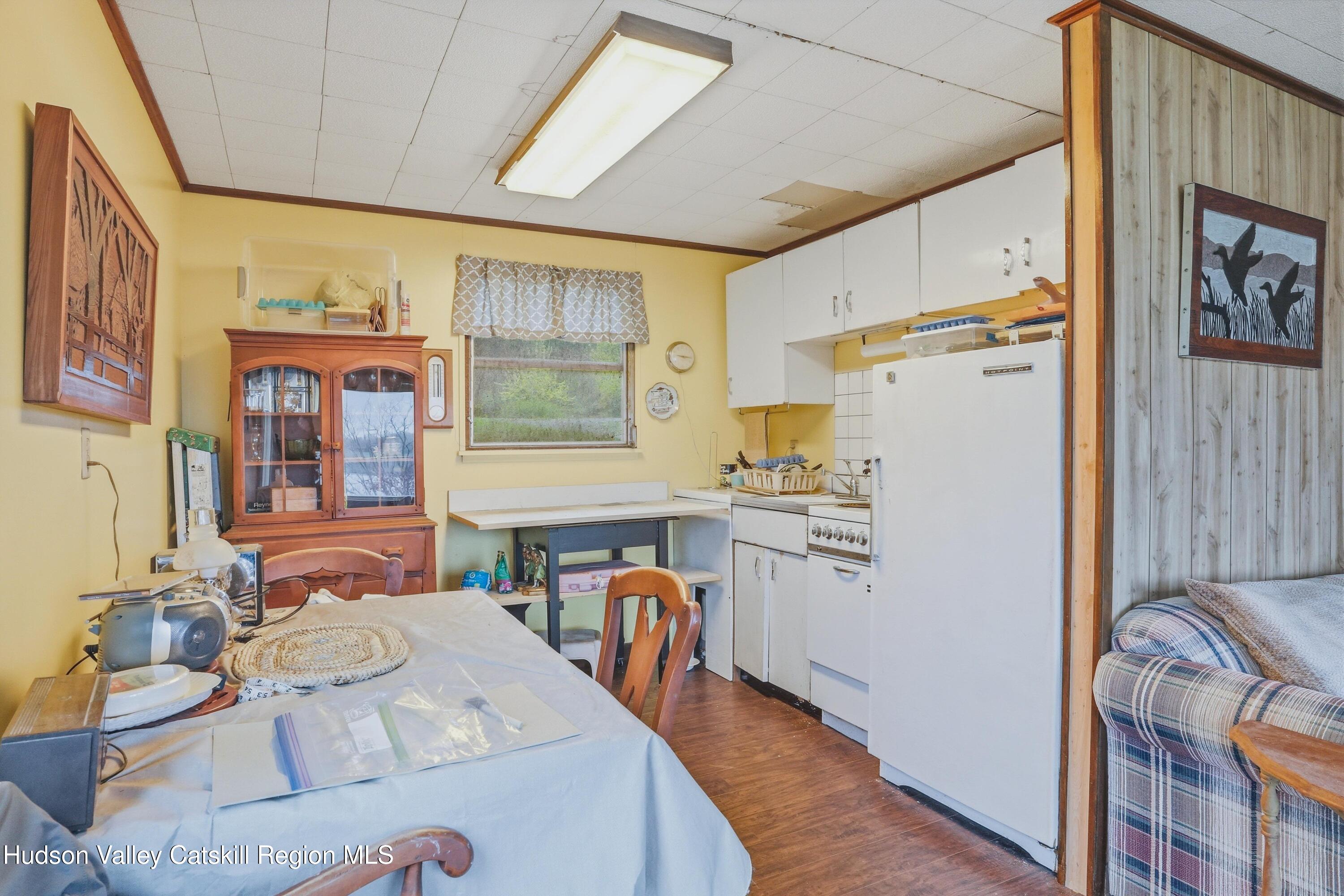 167 Patterson Road West Camp, NY 12490 - Photo 31 of 43 a kitchen with stainless steel appliances a refrigerator a stove a dining table and chairs with wooden floor