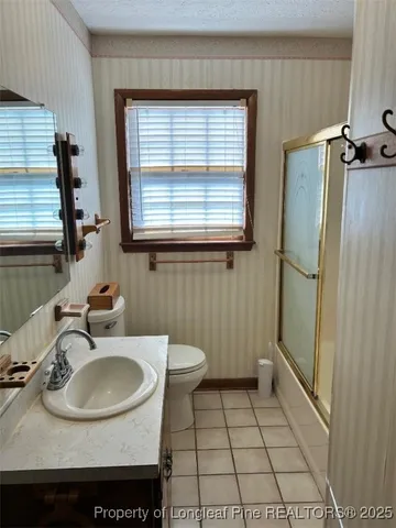 a bathroom with a sink a toilet and a shower