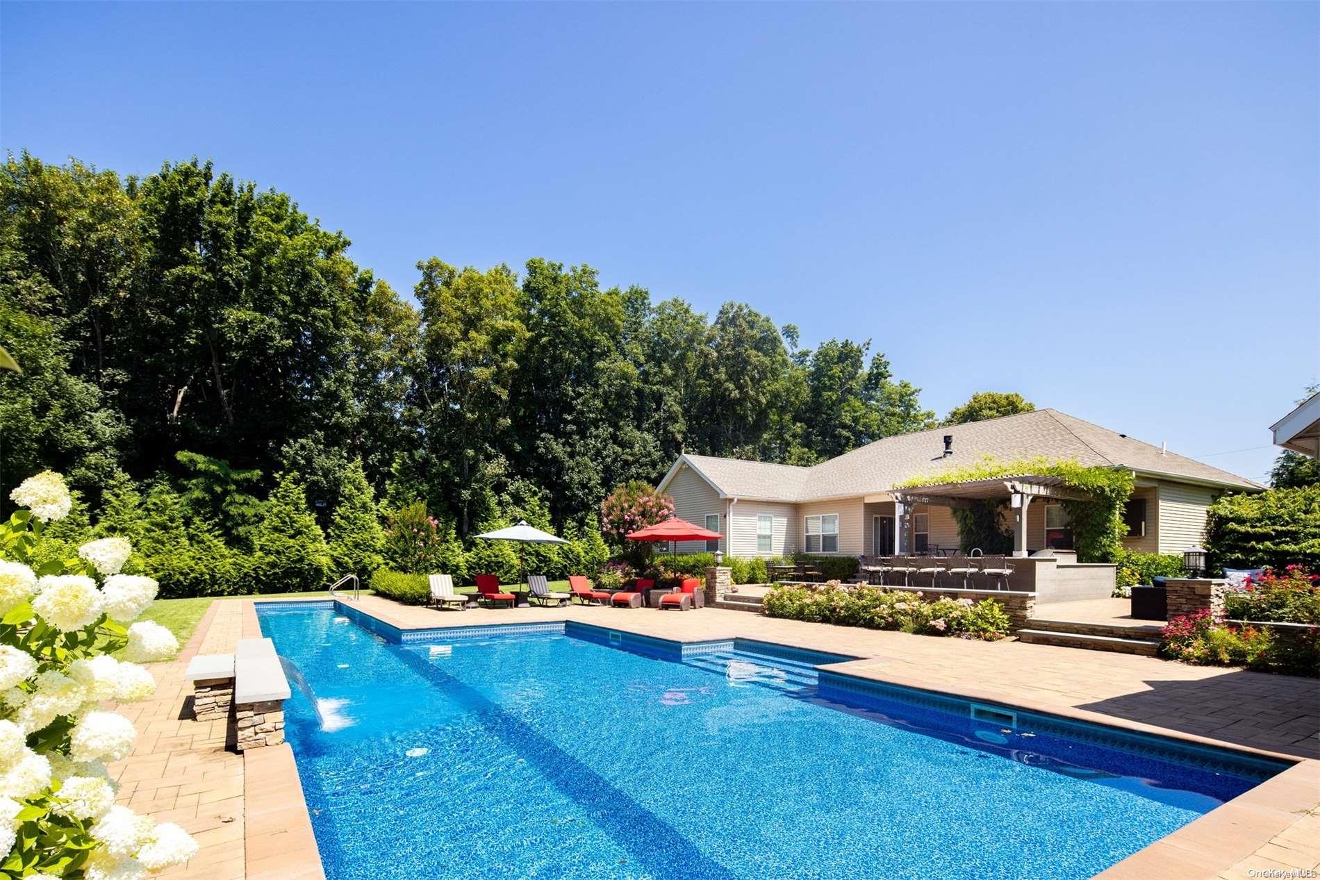 a swimming pool view with a seating space and a garden view