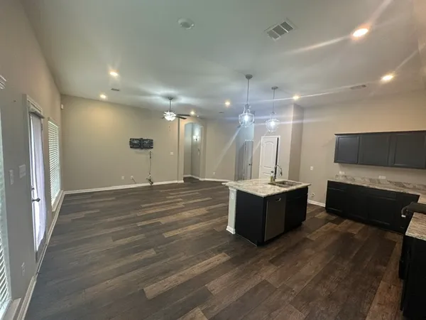 a large room with a lot of counter space and wooden floor