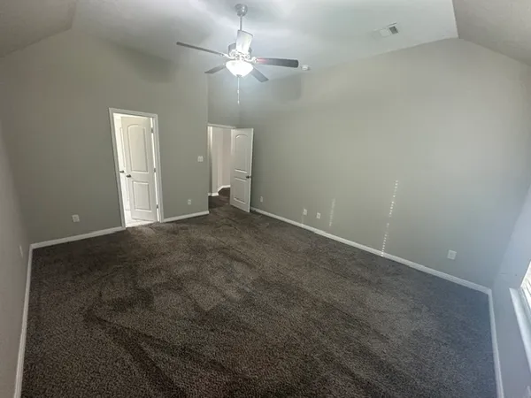 en empty room with windows and fan
