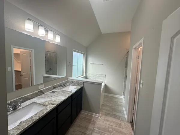 a bathroom with granite countertop double vanity and a sink