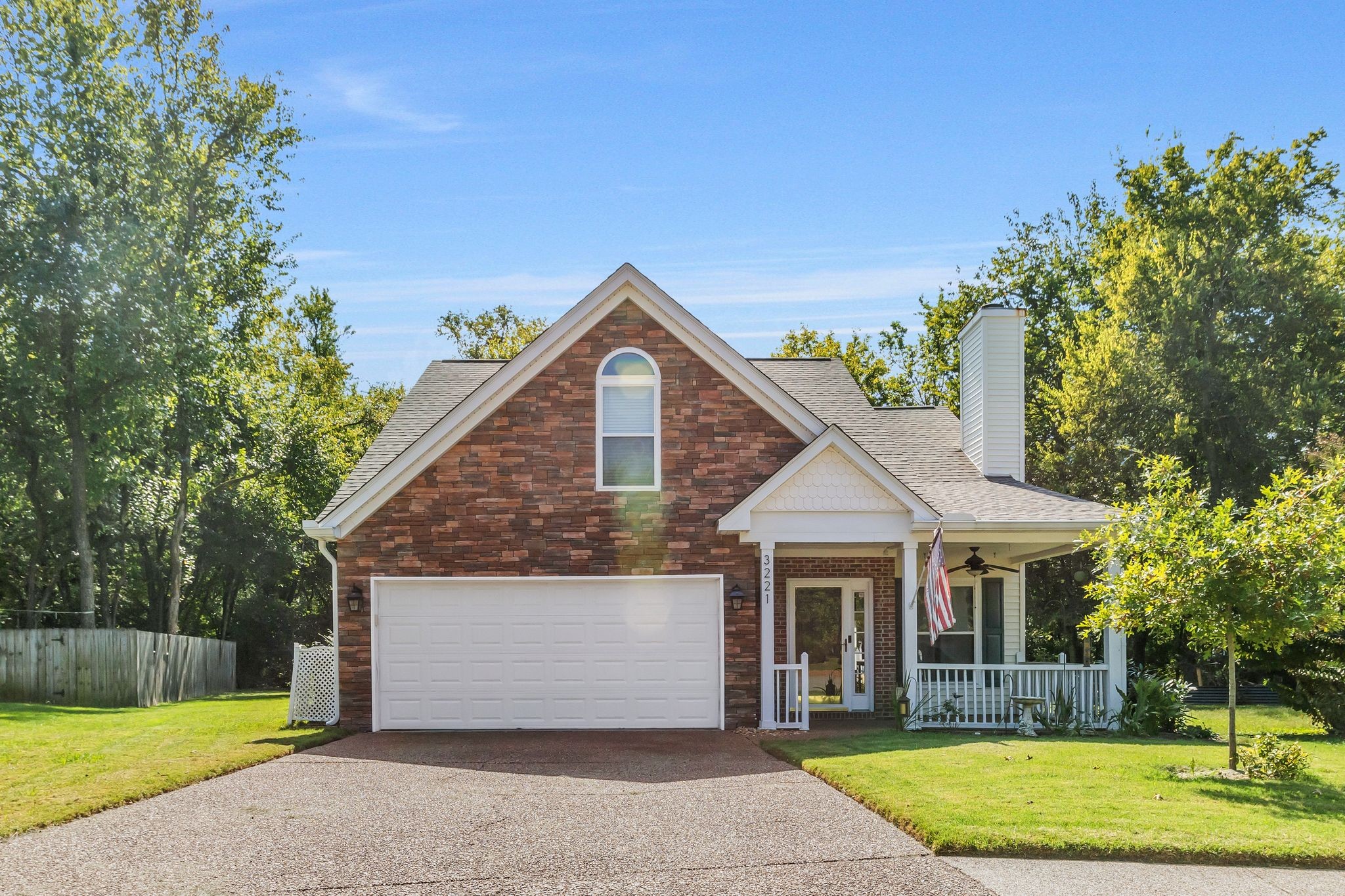 a front view of a house with a yard and trees
