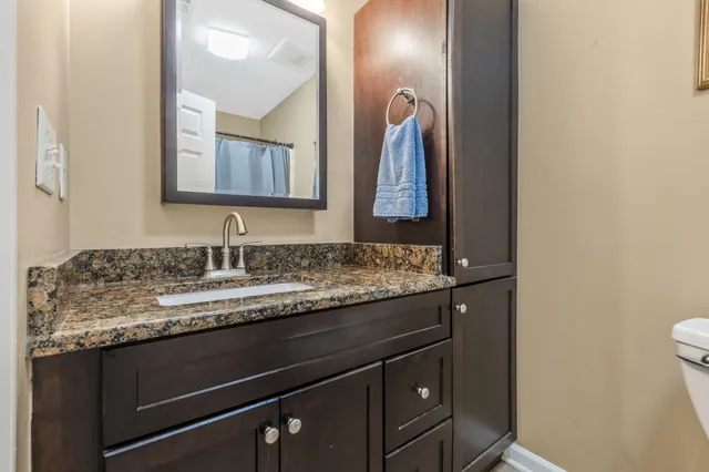 a bathroom with a granite countertop sink and a mirror