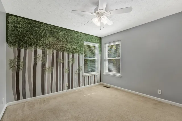 a view of a livingroom with a ceiling fan and window