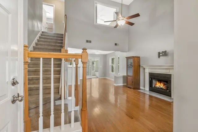 a view of a livingroom with wooden floor a fireplace and a window