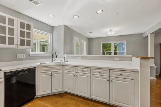 a kitchen with white cabinets and sink