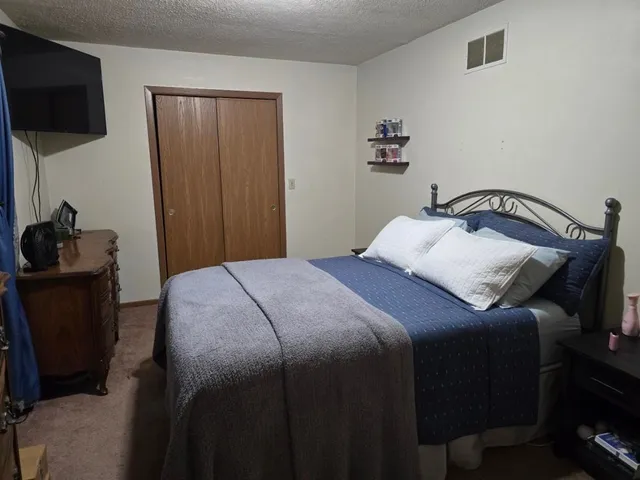a bedroom with a bed and a flat tv screen