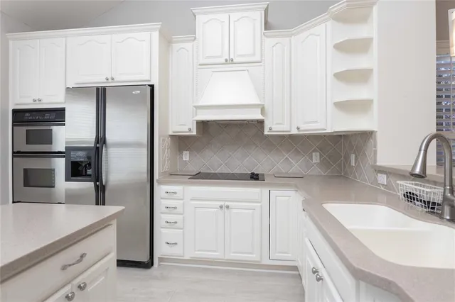 a kitchen with white cabinets and a sink