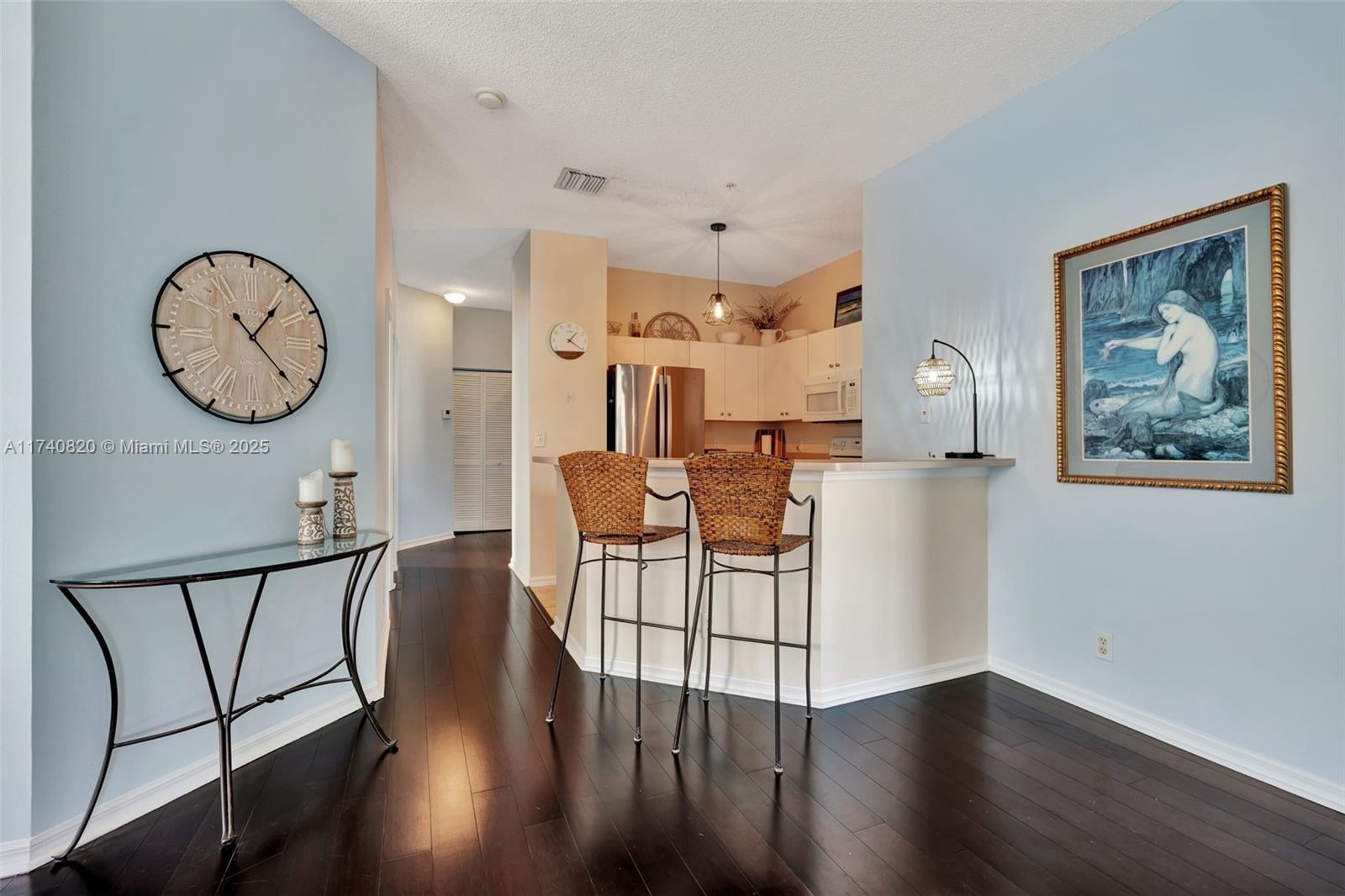 112 Lighthouse Circle, Unit H Tequesta, FL 33469 - Photo 12 of 39 a living room with furniture a wooden floor and a clock
