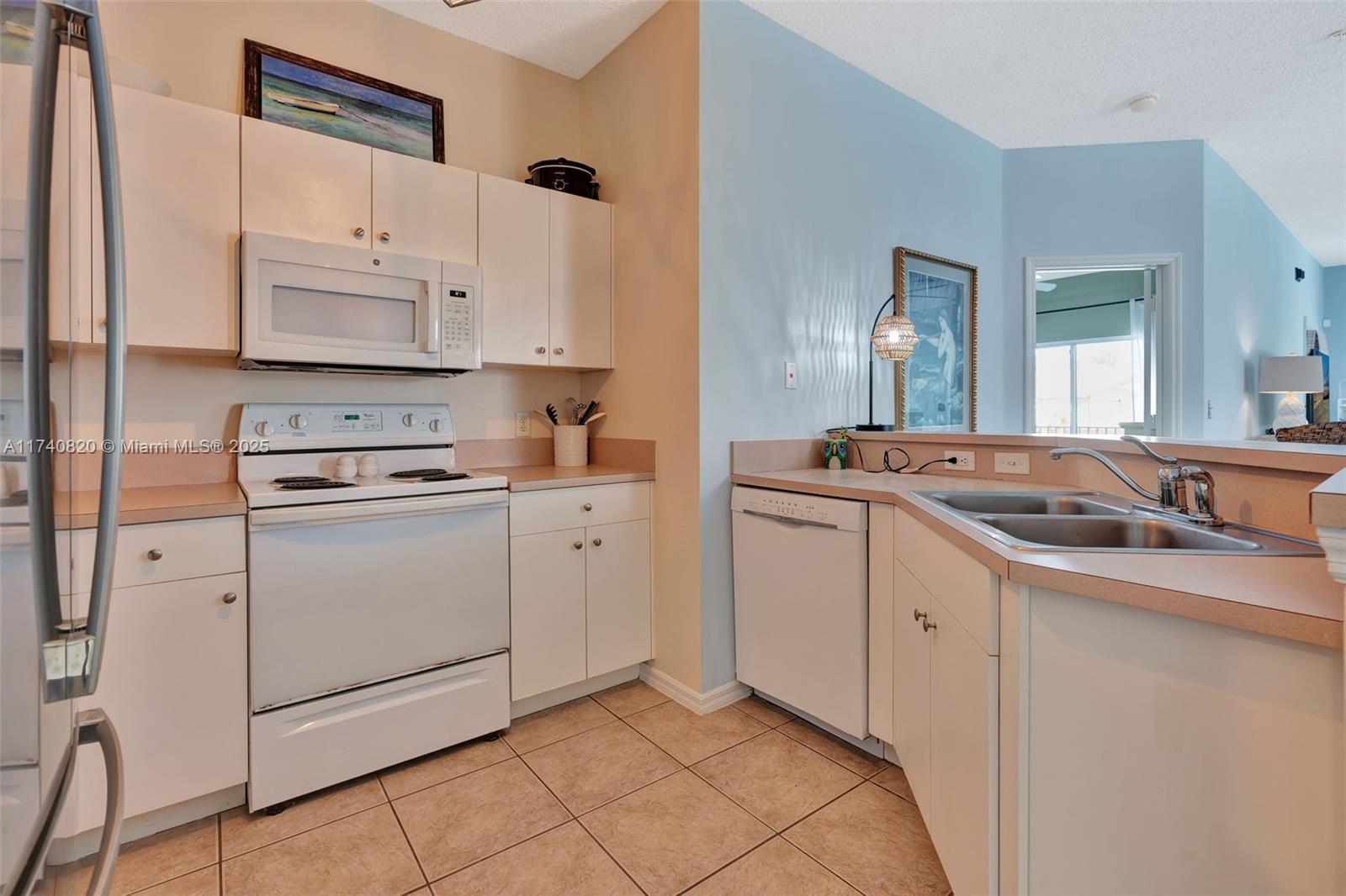 112 Lighthouse Circle, Unit H Tequesta, FL 33469 - Photo 13 of 39 a kitchen with cabinets appliances and a sink
