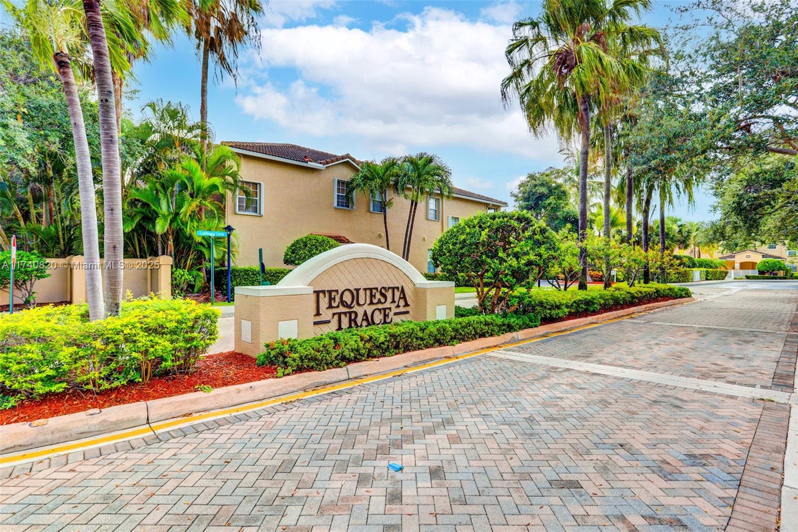 112 Lighthouse Circle, Unit H Tequesta, FL 33469 - Photo 36 of 39 a front view of a house with a yard and potted plants