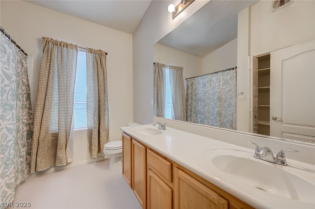 2305 West Horizon Ridge Parkway, Unit 1223 Henderson, NV 89052 - Photo 24 of 28 Bathroom featuring double vanity, a shower with curtain, and healthy amount of natural light