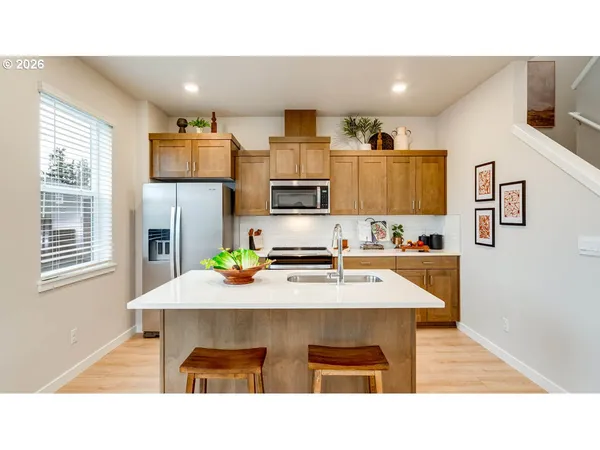 a kitchen with a table chairs refrigerator and microwave