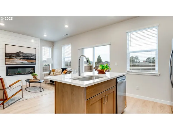 a kitchen with a sink a window and chairs