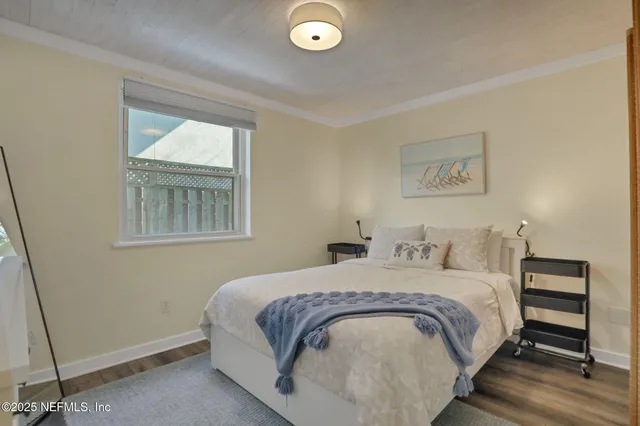 a view of a hallway with wooden floor and a bathroom