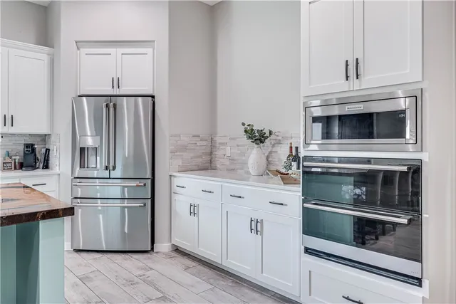 a kitchen with granite countertop white cabinets and stainless steel appliances