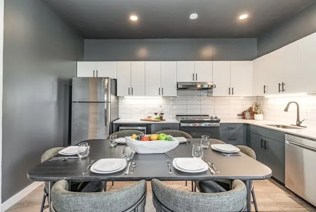 a kitchen with stainless steel appliances granite countertop a sink stove and refrigerator