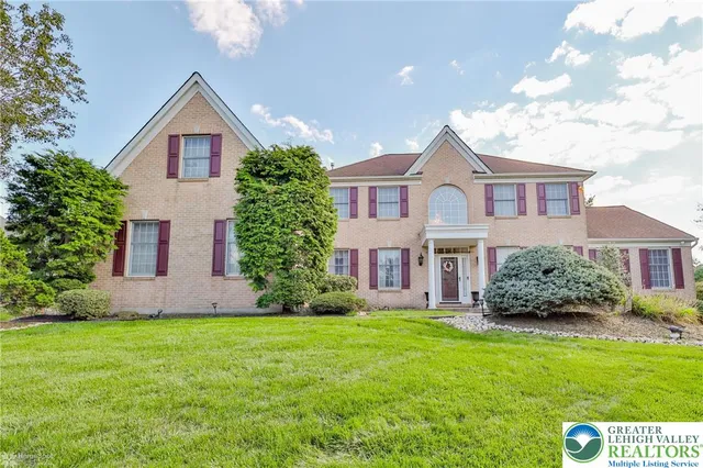 a front view of a house with a garden and plants