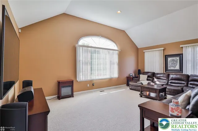 a bedroom with a bed flat screen tv and a chandelier