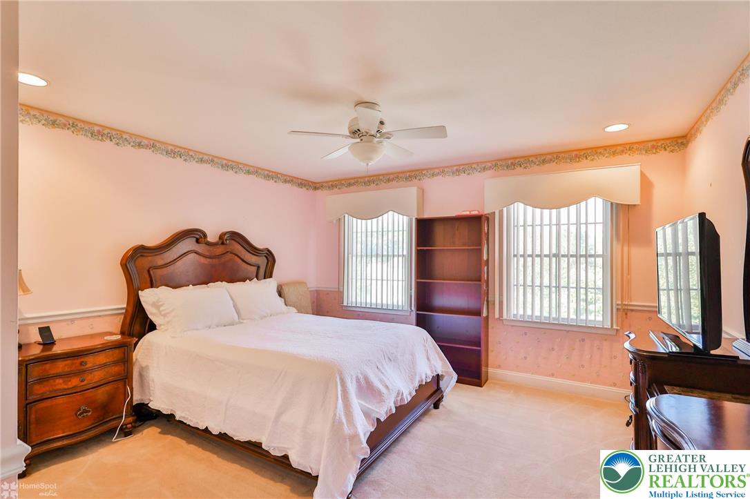 1991 Autumn Ridge Road Lower Macungie Township, PA 18062 - Photo 46 of 71 a bedroom with a bed flat screen tv and a chandelier
