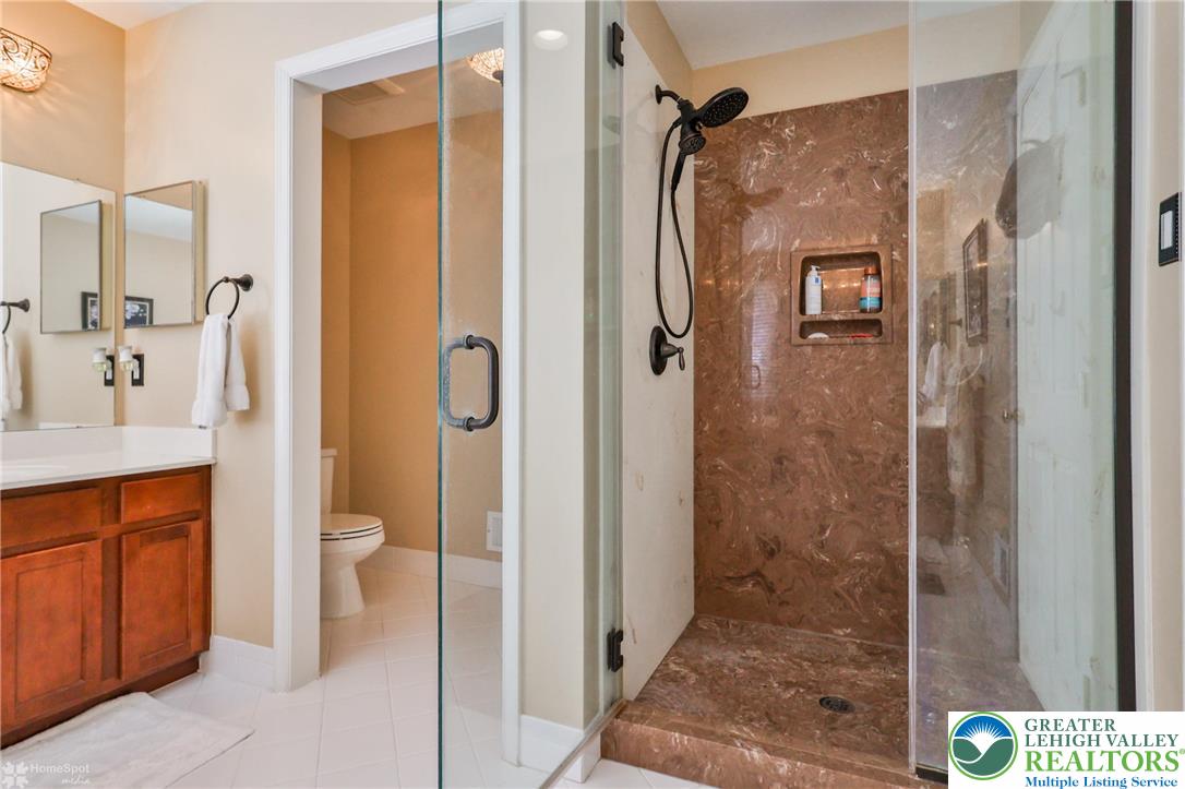 1991 Autumn Ridge Road Lower Macungie Township, PA 18062 - Photo 60 of 71 a bathroom with a granite countertop shower mirror and a toilet