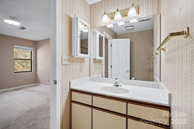 a bathroom with a sink vanity granite and a mirror