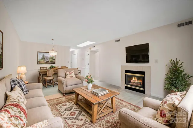 a living room with furniture a flat screen tv and a fireplace
