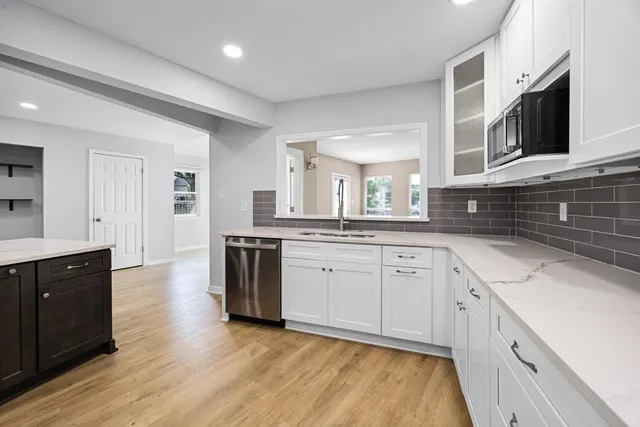 a kitchen with stainless steel appliances granite countertop white cabinets a sink and dishwasher