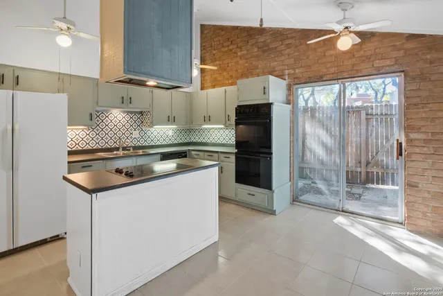 a kitchen with stainless steel appliances granite countertop a refrigerator and a stove