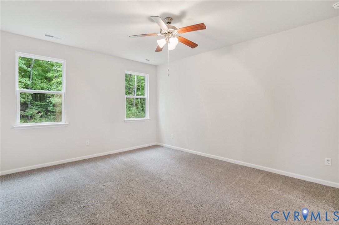 7784 Patriots Way Gloucester, VA 23061 - Photo 11 of 32 an empty room with a window and a fan