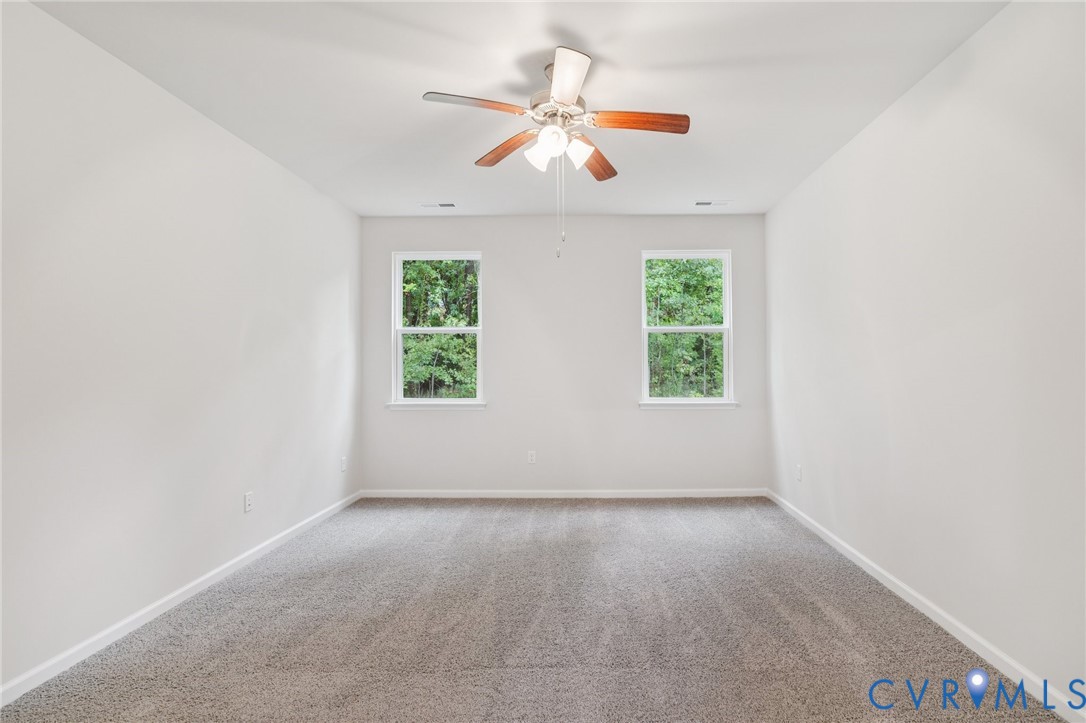 7784 Patriots Way Gloucester, VA 23061 - Photo 12 of 32 an empty room with windows and ceiling fan