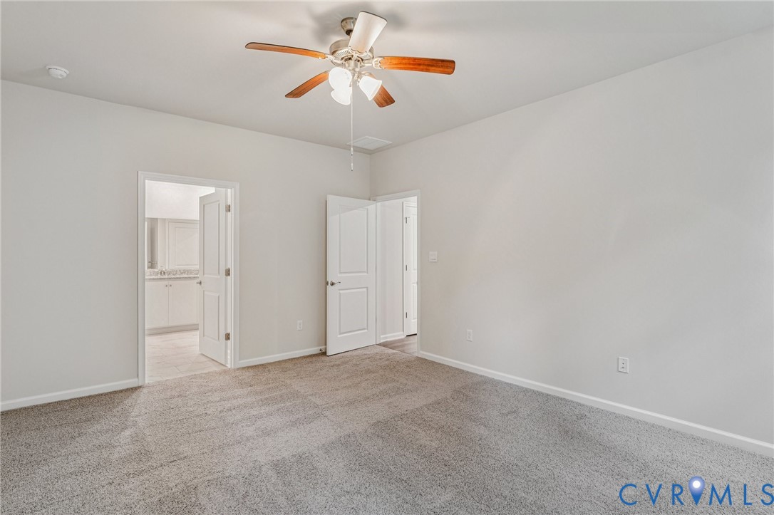 7784 Patriots Way Gloucester, VA 23061 - Photo 27 of 32 an empty room with a chandelier fan and windows